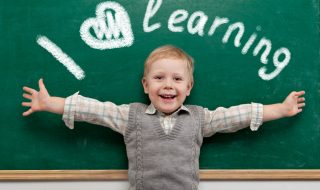 Cheerful smiling child at the blackboard.