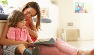 Mother Sitting With Son Reading Story Indoors